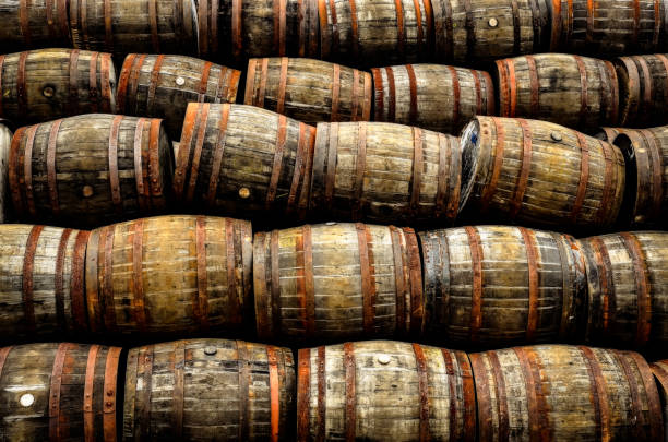 Stacked pile of old whisky and wine wooden barrels stock photo