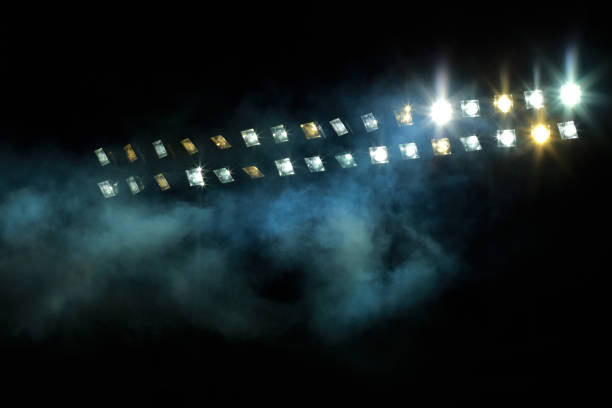 Stadium lights against dark night sky stock photo