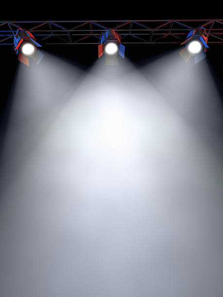 Stage Lights A Stage Light Rack with 3 Spotlights Shining down towards the middle of the layout in a dark area. staging light stock pictures, royalty-free photos & images