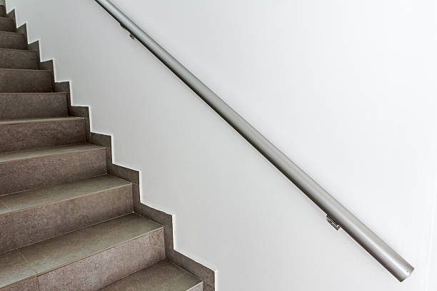 Staircase is going up Stairway with metallic banister in a new modern building. Every building is required to have emergency stairways as safety measure. bannister stock pictures, royalty-free photos & images