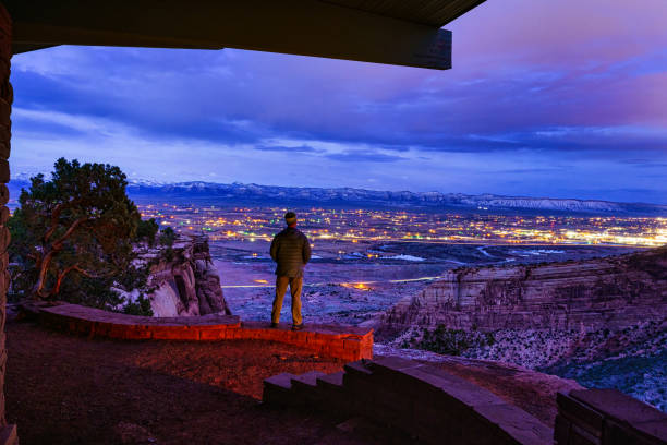 Standing on Rocks Overlooking Grand Junction Colorado at Night Standing on Rocks Overlooking Grand Junction Colorado at Night - Night view looking down from Colorado National Monument overlooking the town of Fruita and small city of Grand Junction, Colorado USA. colorado plateau stock pictures, royalty-free photos & images