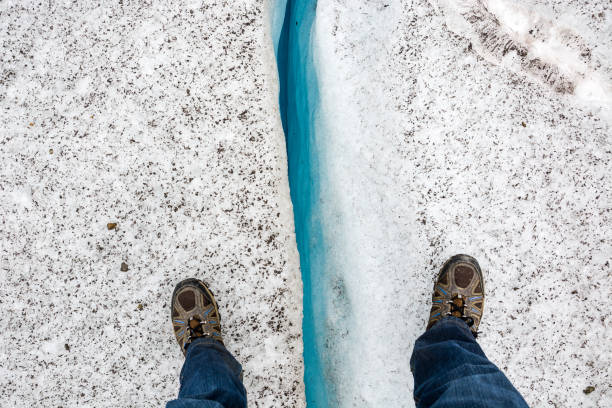 Standing over a crevice Standing over a crevice on a glacier crevice stock pictures, royalty-free photos & images