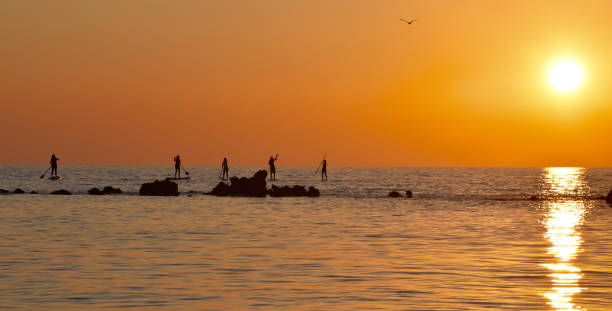 Stand-up Paddlers Sunset Corfu, Greece stock photo