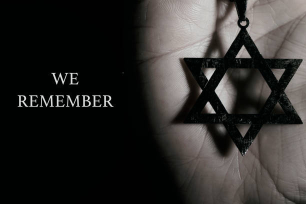 star of david in a pendant and text we remember closeup of an old and rusty pendant in the shape of the star of david on the hand of a man and the text we remember, as a memory of the dead jewish people holocaust remembrance day stock pictures, royalty-free photos & images