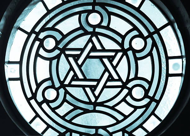 Stain-glass Window in 19 century Synagogue. Stain-glass with a dramatic back light overtone. The Star of David, known in Hebrew as the Shield of David or Magen David, is the quintessential symbol of Jewish identity.