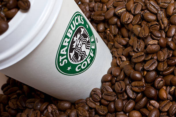 Starbucks cup with coffee beans stock photo