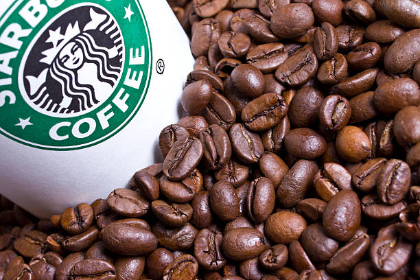 Starbucks cup with coffee beans stock photo
