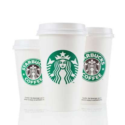 Newcastle upon Tyne, England - March 8, 2011:  Three Starbucks to-go cups isolated on white.  Starbucks is the world's largest coffeehouse company.  The cup in the center shows the newest version of the logo which launched world wide in 2011.