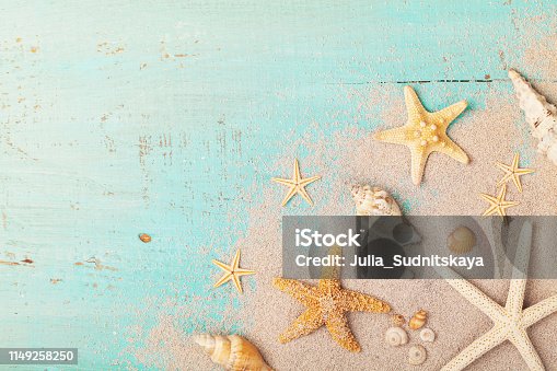 istock Starfishes and seashells on sand for summer holidays and travel background. 1149258250