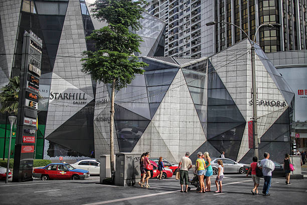Starhill Gallery Kuala Lumpur, Malaysia - June 13, 2013: Starhill Gallery is one of the most recognizable shopping malls in Kuala Lumpur. It's located at the end of the Bintang Walk (181 Jalan Bukit Bintang), in the center of Kuala Lumpur. Nearby popular malls are Pavilion KL (directly opposite) and Fahrenheit88 (next door neighbor). Costumers and pedestrians can be seen walking by, with taxis and cars on the road. bukit bintang stock pictures, royalty-free photos & images