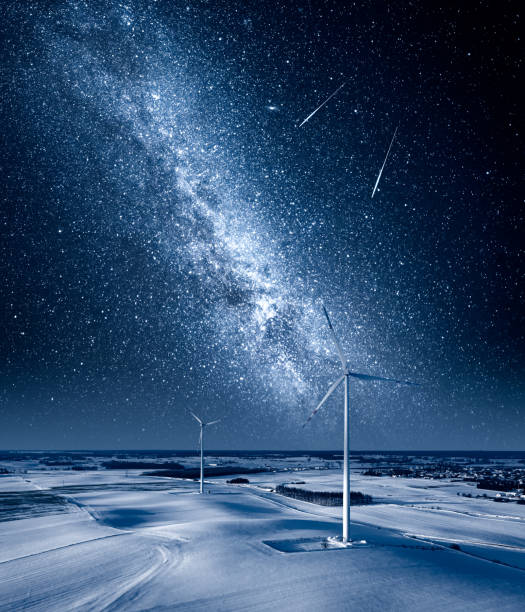 Stars over wind turbine on field. Winter sky at night. stock photo