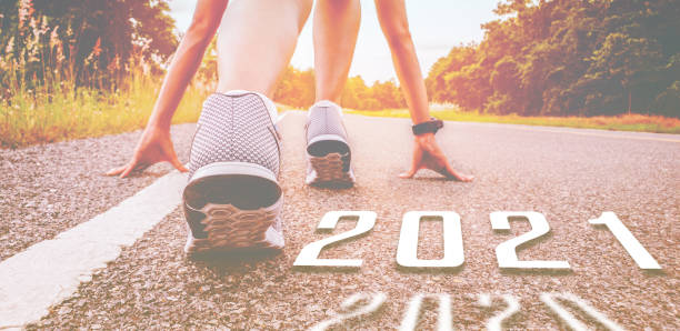 Start 2021 symbolises the start into new year. The start of people running on street is healthy new normal, with sunset light. Goal of Success  2021 stock pictures, royalty-free photos & images