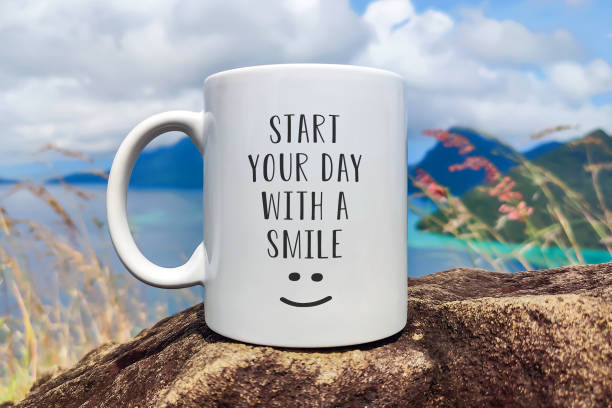 Start your day with a smile greeting with a happy smile on a cup of coffee with sea background. stock photo