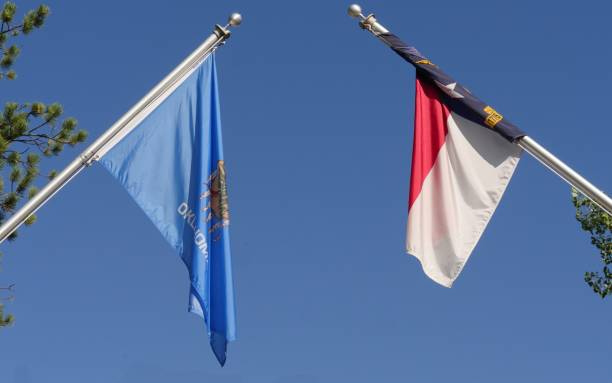 State flags of Oklahoma and North Carolina hanging unfurled from poles stock photo