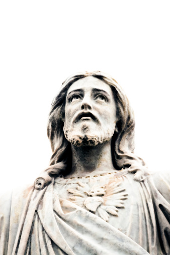 Closeup old marble statue of Jesus Christ looking up against white background from cemetery 1877, Sydney Australia, full frame vertical composition with copy space