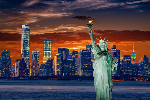 Statue Of Liberty And New York City Skyline At Sunset With Manhattan