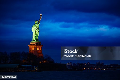 istock Statue of Liberty over New York night cityscape 1287984192