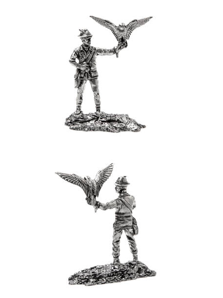 Statuette of a hunter in a hat holding a falcon on his hand. Silver figurine of a man with a bird on his hand. Isolate on a white background. stock photo