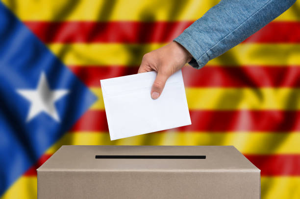 Statute of Autonomy of Catalonia - voting at the ballot box Statute of Autonomy of Catalonia - voting at the ballot box. The hand of woman putting her vote in the ballot box. Catalan flag on background. catalonia stock pictures, royalty-free photos & images