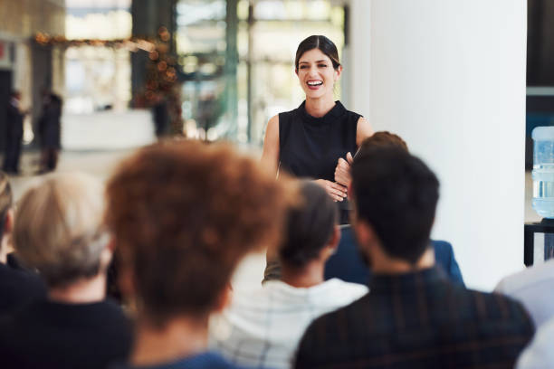 Stay current with trends by learning from powerful speakers Shot of a young businesswoman delivering a speech during a conference corporate stock pictures, royalty-free photos & images