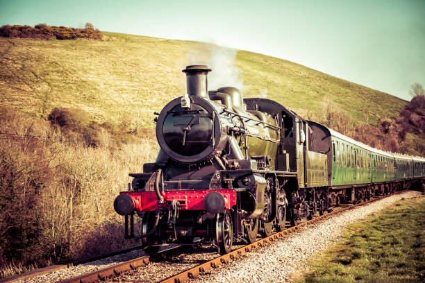 Steam Train Moving Swiftly through the Country Hills Steam Engine gently passing the English Countryside. train vehicle photos stock pictures, royalty-free photos & images