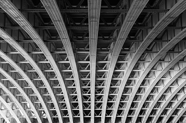 Steel lines under a bridge in London Symmetric steel framework under a bridge over the river Thames in London. architectural feature stock pictures, royalty-free photos & images