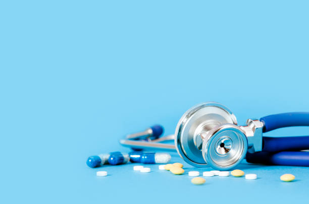 stethoscoop en pillen op blauwe achtergrond - white oxycodone stockfoto's en -beelden