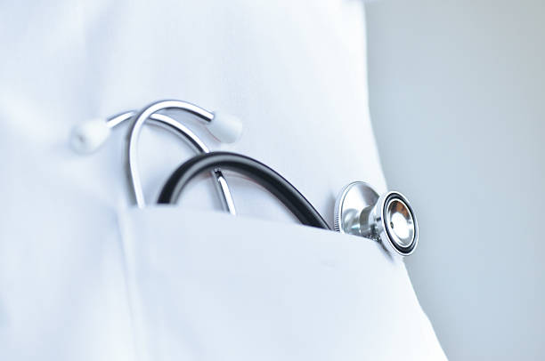 Stethoscope In doctor's lab coat pocket Macro of Stethoscope In doctors lab coat pocket. lab coat stock pictures, royalty-free photos & images