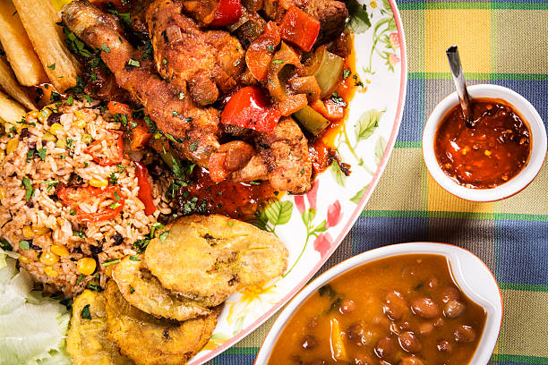 Stewed chicken with vegetables and rise Stewed chicken with vegetables prepared in a typical Creole way served with rice, potato croquettes, beans and chili sauce. caribbean culture stock pictures, royalty-free photos & images