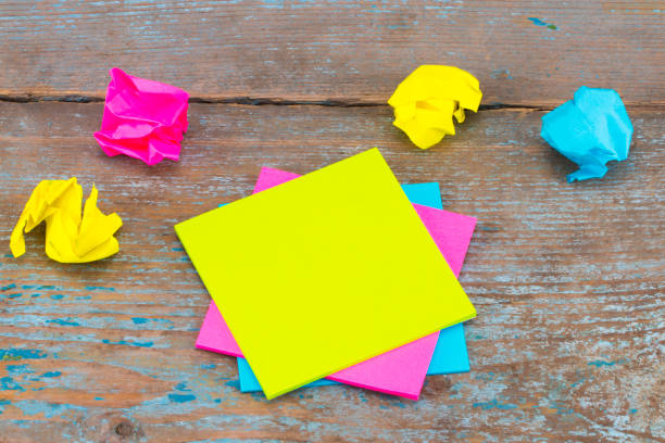 sticky note with crumpled papers  on wooden background, business concept on the sticky note stock photo