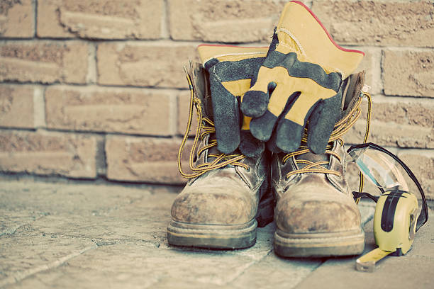Still life containing work boots, gloves, and measuring tape stock photo