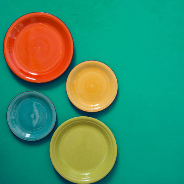 Still life - four colorful dishes on the edge of a green background stock photo