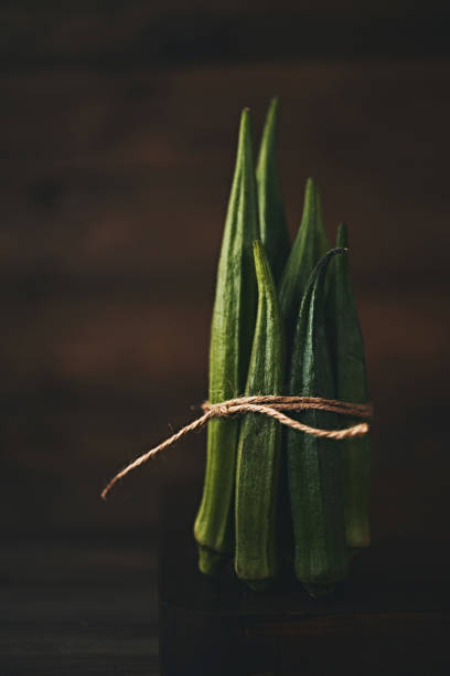 Still life of bundled okra shot in dark moody light Still life of bundled okra shot in dark moody light okra photos stock pictures, royalty-free photos & images