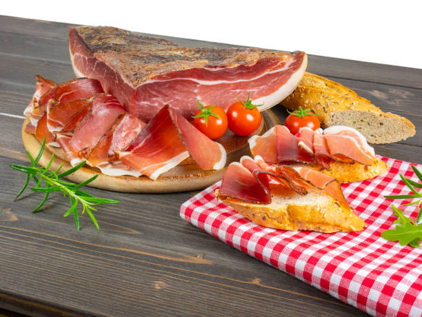 Still life of speck. Bread and slices of speck. Traditional smoked ham from south tyrol. Rustic appetizers. stock photo