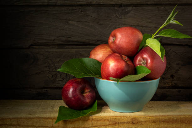 Still life with blue bowl ripe apples on wooden background Blue bowl with apples. Still life with ripe apples on wooden background in rustic style. Beautiful background with harvest of red apples. still life stock pictures, royalty-free photos & images