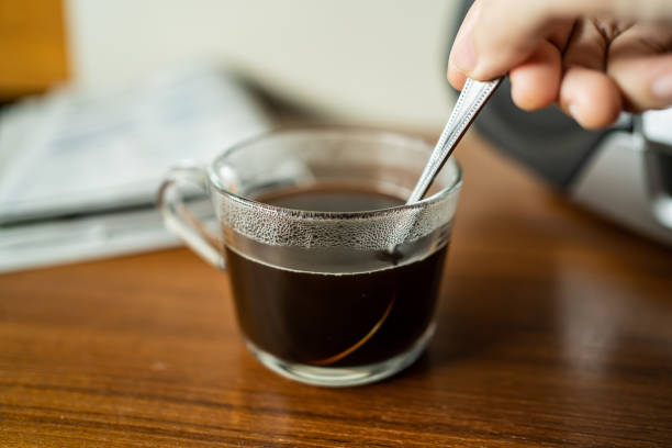 Stirring coffee in a cup with teaspoon stock photo