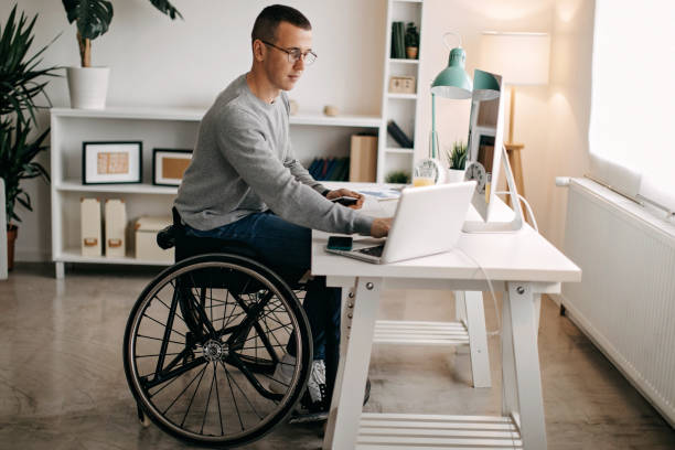 Stock market is twisty today Young man with disabilities working on his stock market portfolio wheelchair stock pictures, royalty-free photos & images