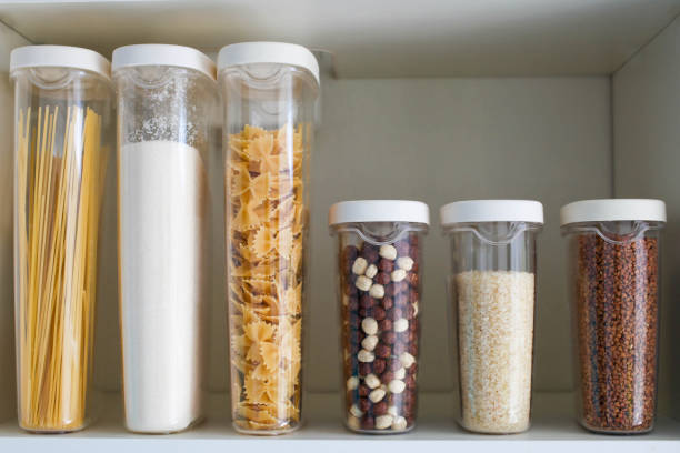 Stocked kitchen pantry with food - pasta, buckwheat, rice and sugar . Stocked kitchen pantry with food - pasta, buckwheat, rice and sugar . The organization and storage in kitchen of a case with grain in plastic containers. pantry stock pictures, royalty-free photos & images