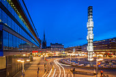 The iconic Kristall obelisk illuminated in the centre of Sergels torg, the modern public square in the heart of Stockholm, overlooking the pedestrianised plaza, traffic roundabout, Kulturhuset, shops and office buildings glowing under the blue dusk sky. ProPhoto RGB profile for maximum color fidelity and gamut.