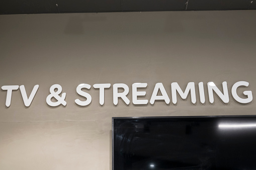 A sign saying TV and Streaming in an electronics store and a TV.