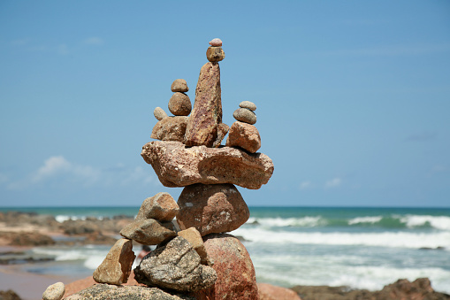 salvador, bahia, brazil - september 16, 2021: stones stack forming a perfect balance along Itapua beach in Salvador city.