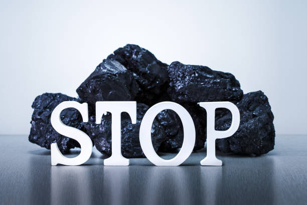 Stop coal mining concept. Word STOP with Coal Stack on grey background. stock photo