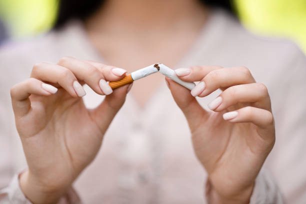 금연 개념. 청록색 배경에 담배를 깨는 십대 남자, 선택적 초점 - 니코틴 뉴스 사진 이미지