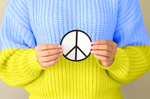Symbol of peace in Ukraine and Ukrainian Flag sweater. Stop war concept