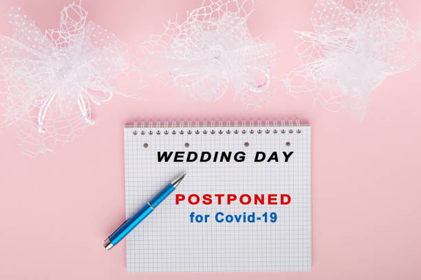 Stop wedding for coronavirus pandemy mock up Flat lay mock up with block notes on pink table with text to postponed wedding for coronavirus with copy space in minimal style. postponed stock pictures, royalty-free photos & images