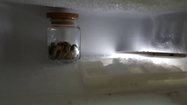 storing coins in jar in refrigerator money storage methods stock photo