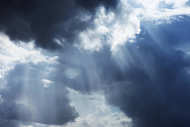 Storm cloudscape with sunbeams on a dramatic sky Sunlight breaks through storm clouds. Something divine..   sky only stock pictures, royalty-free photos & images