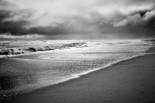 Stormy sea, beach and clouds at dark dramatic. Sunlight, back lit