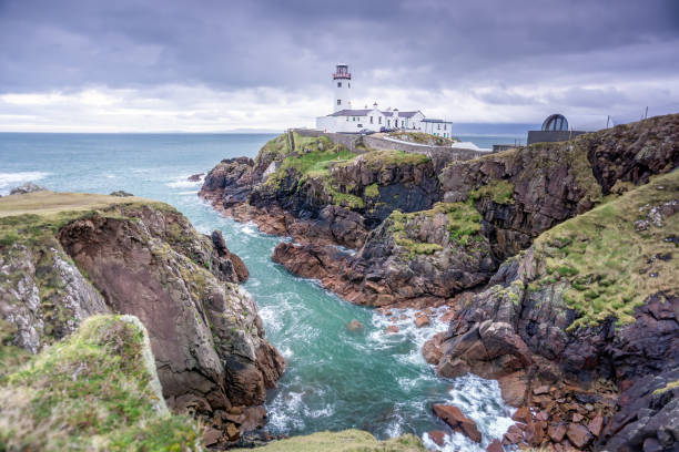 Stormy sky at Fanad Head Lighthouse on Wild Atlantic Way. Stormy sky at Fanad Head Lighthouse on Wild Atlantic Way. Beautiful Fanad Head peninsula with cliffs and turquoise water below, Donegal, Ireland wild atlantic way stock pictures, royalty-free photos & images
