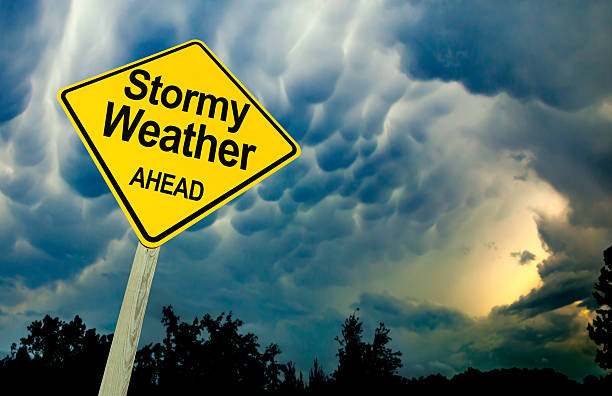 Stormy Weather Ahead Road Sign Against Dark Ominous Sky stock photo